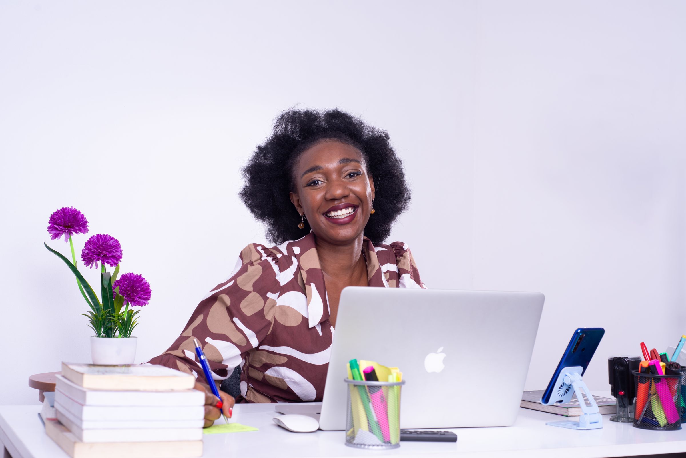 A businesswoman smiling at her desk with a laptop